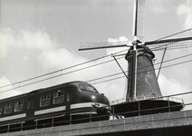 169118 Gezicht op de molen De Roos aan de Phoenixstraat te Delft, met op de voorgrond een electrisch treinstel plan V ...